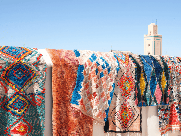 Bight moroccan rugs and runners hanging in the sun in Marrakech - Nouvelle Nomad