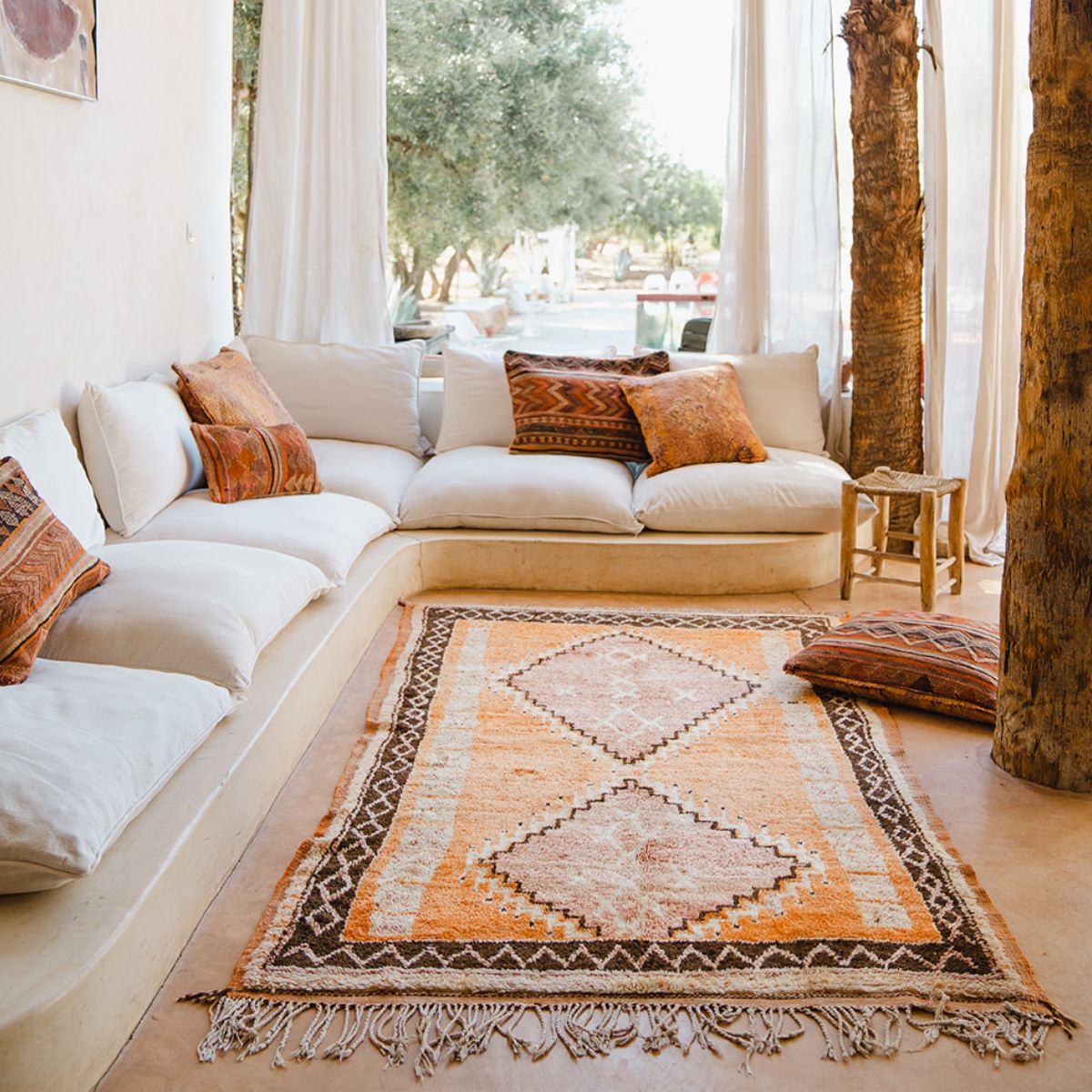 Orange Moroccan rug on the floor with couch - Nouvelle Nomad