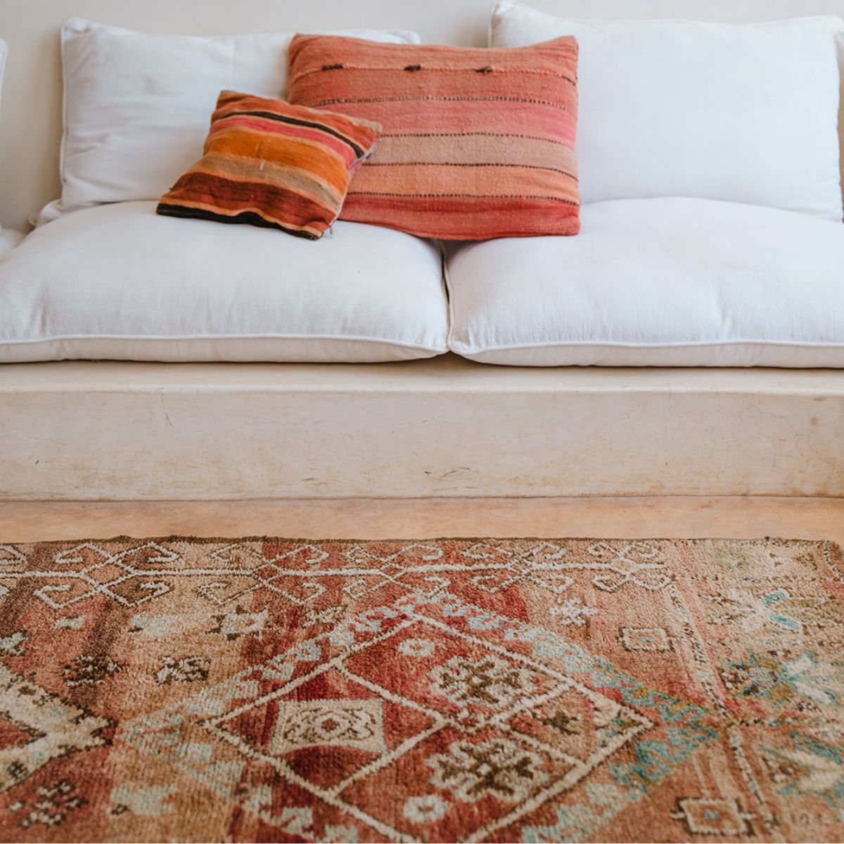 Terracotta Moroccan rug on the floor in front of couch - Nouvelle Nomad