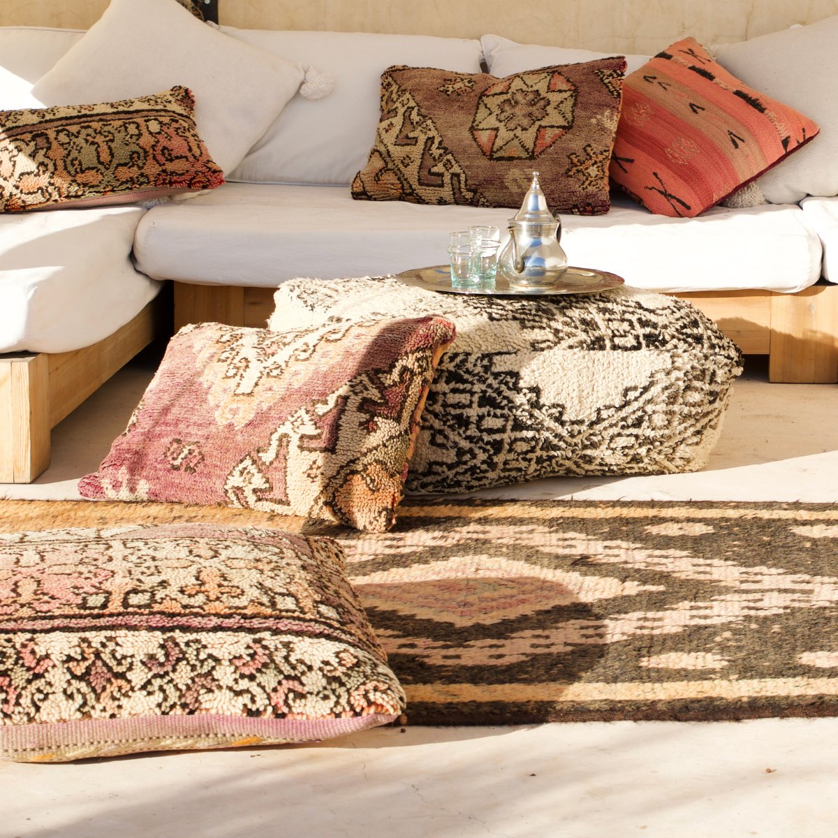 Vintage Moroccan cushions and floor cushions scattered on the ground - Nouvelle Nomad