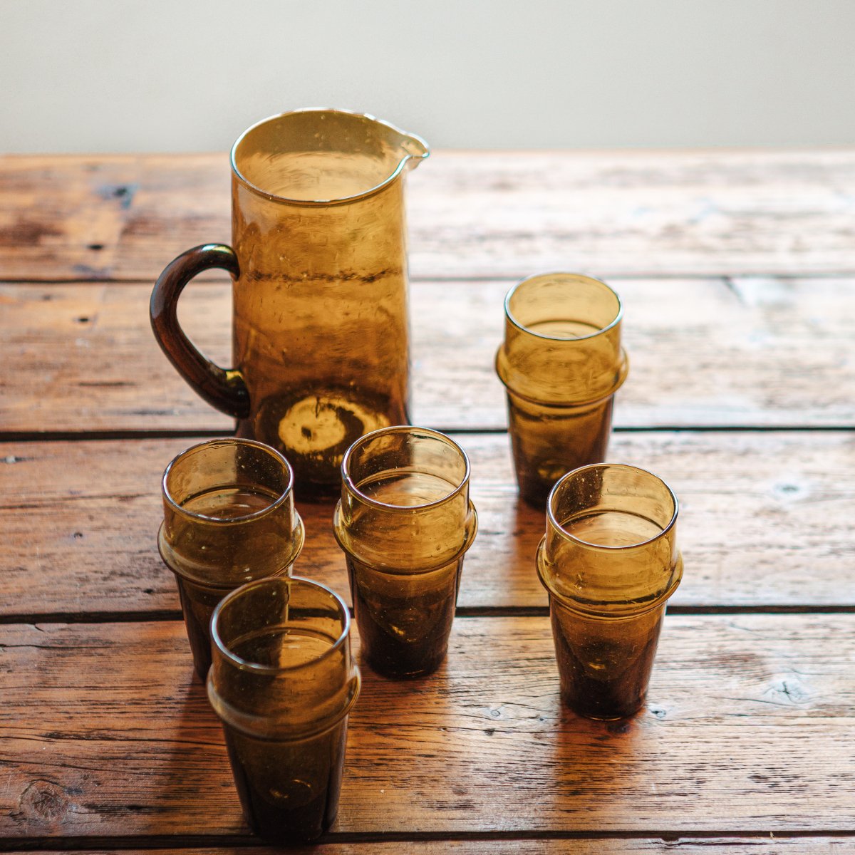 Amber coloured Moroccan Beldi Glass Jug and drinking glasses on a timber table - Nouvelle Nomad