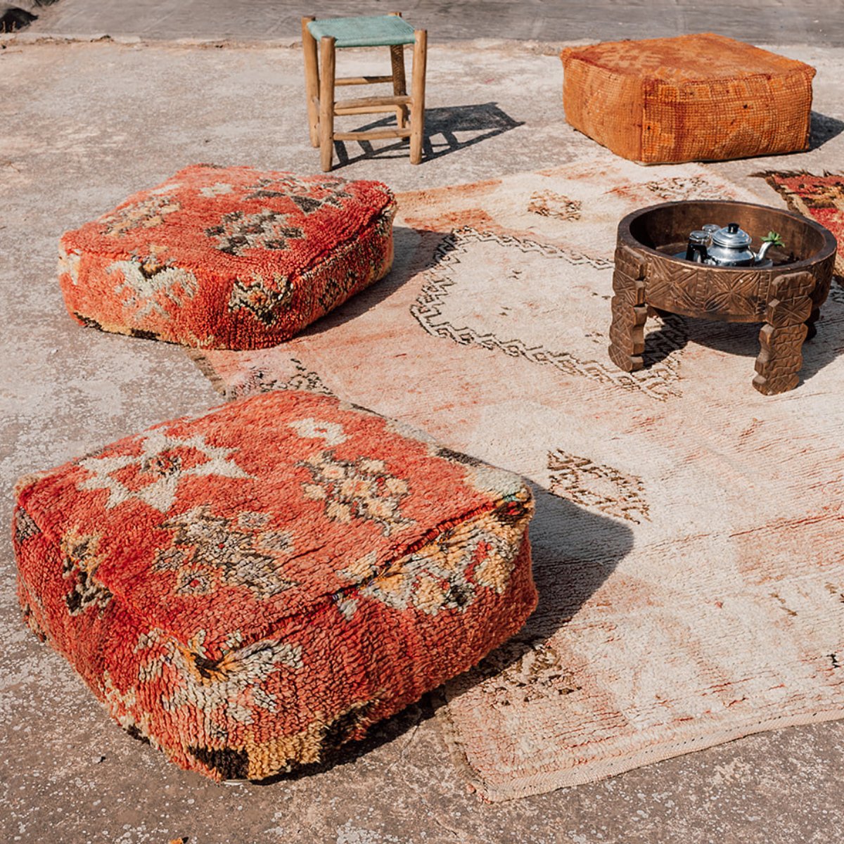 Vintage Moroccan Floor Cushions scattered on the ground with vintage rugs - Nouvelle Nomad