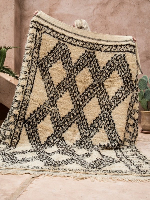 A shaggy high pile vintage Ben Ourain rug being held up - Nouvelle Nomad