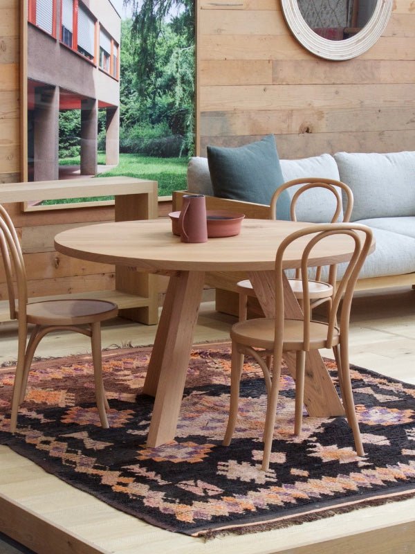Black Moroccan rug under a circular Mark Tuckey dining table and chairs - Nouvelle Nomad