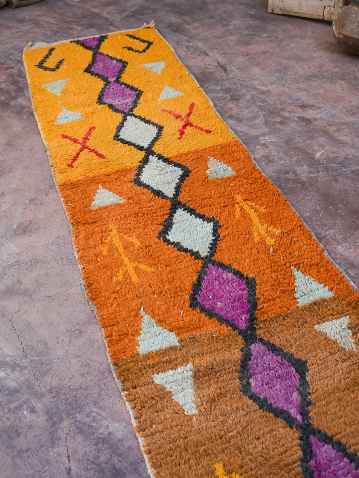 Newly handwoven Moroccan runner rug in vibrant orange with terracotta, purple and black diamond design. Soft, plush 100% wool with natural wool fringe and one end.