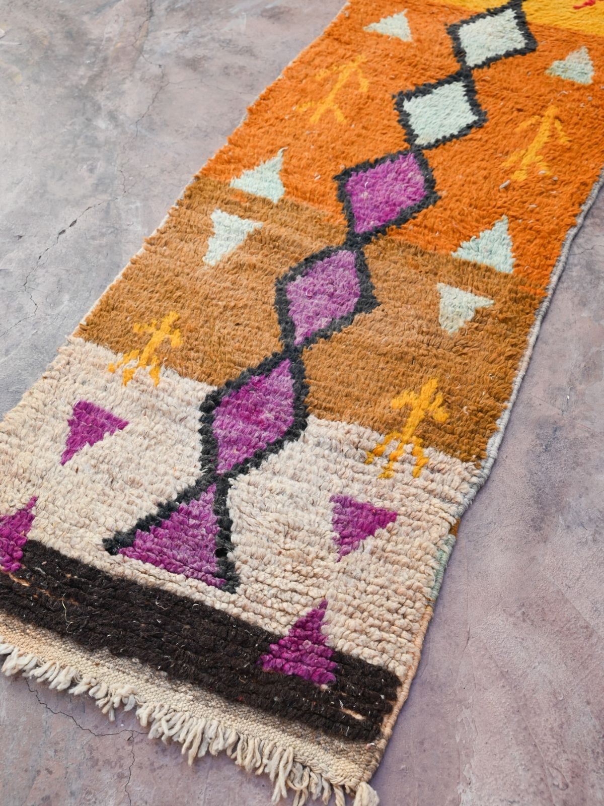 Newly handwoven Moroccan runner rug in vibrant orange with terracotta, purple and black diamond design. Soft, plush 100% wool with natural wool fringe and one end.