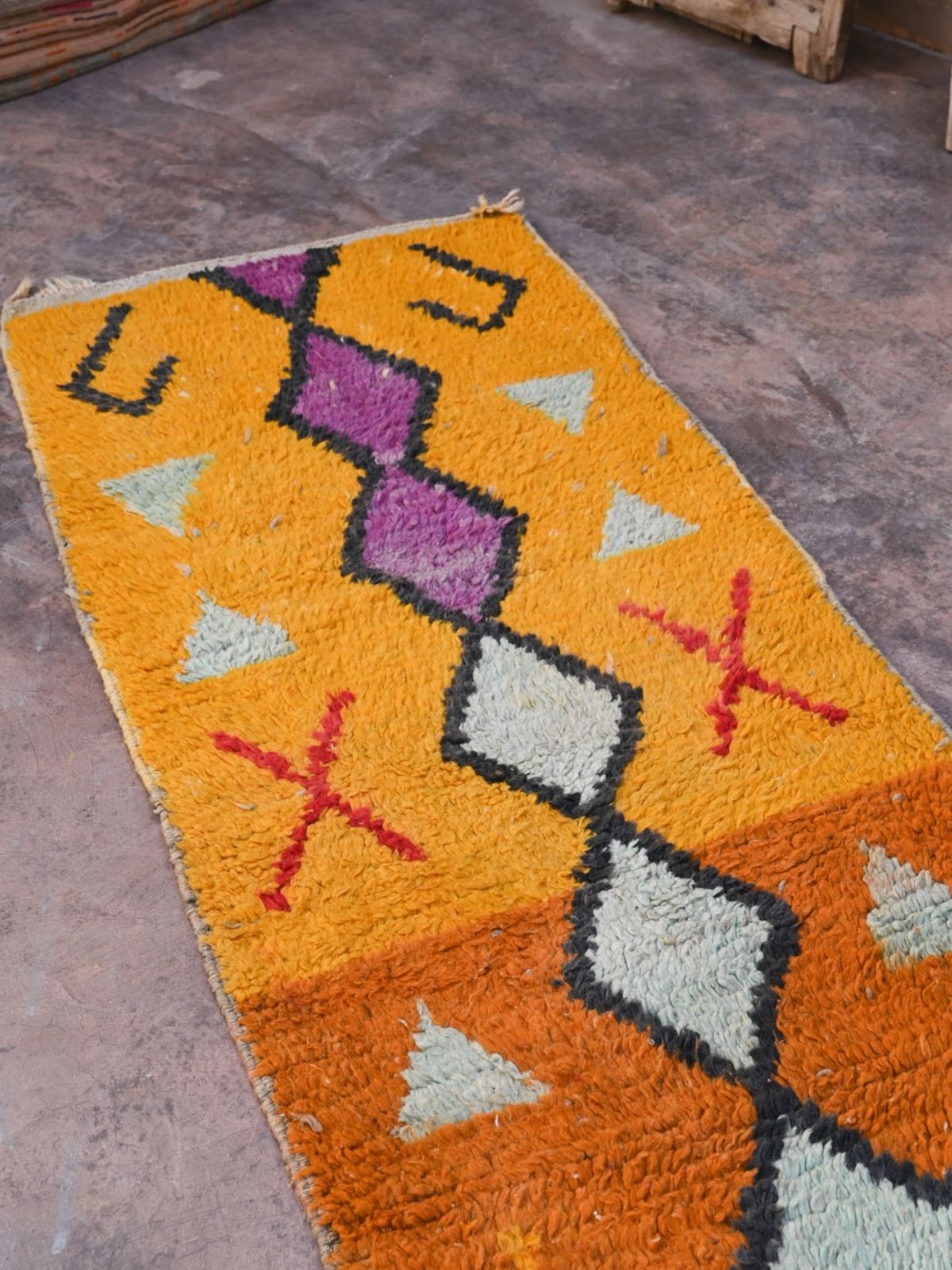 Newly handwoven Moroccan runner rug in vibrant orange with terracotta, purple and black diamond design. Soft, plush 100% wool with natural wool fringe and one end.