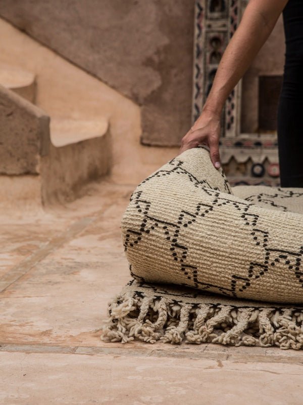 A folded up vintage Beni Ourain rug being held - Nouvelle Nomad