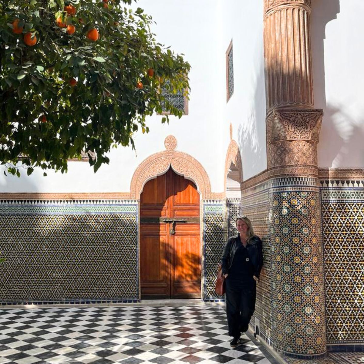 Bridget from Nouvelle Nomad standing in the tiled courtyard at Dar El Bacha in Marrakech