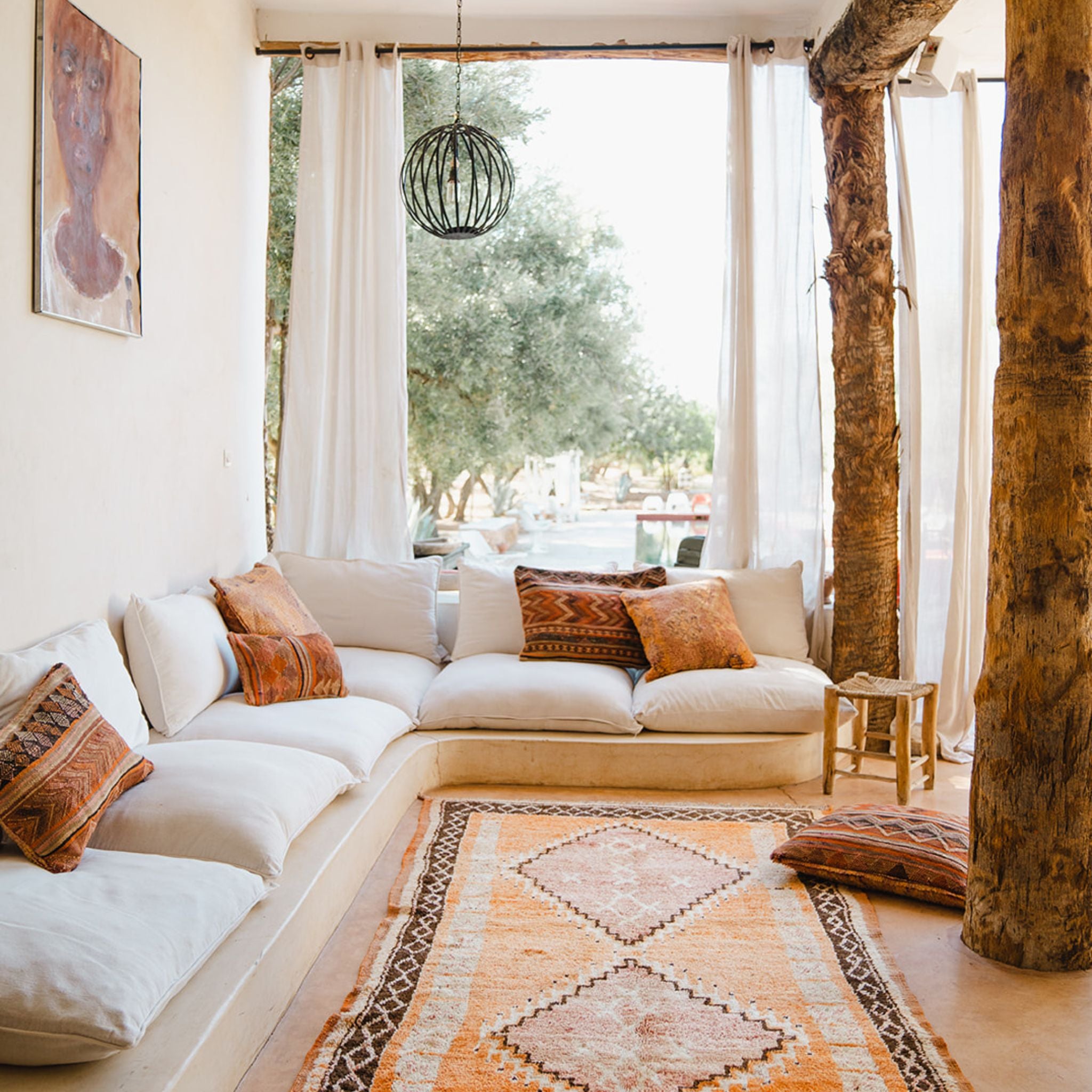 A Terracotta Coloured Vintage Moroccan Rug and Cushions in front of a couch in Marrakech Morocco