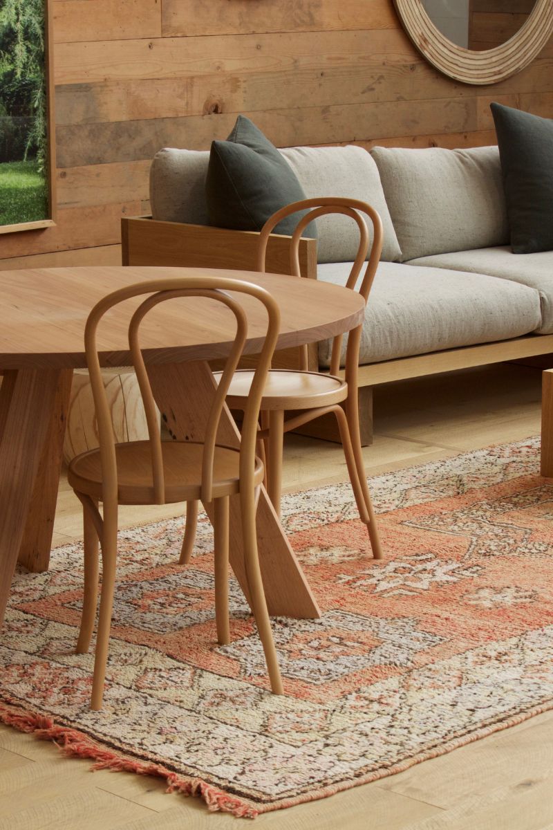 A peach coloured vintage Moroccan rug on the floor in a Mark Tuckey furniture showroom