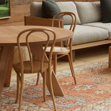 A peach coloured vintage Moroccan rug on the floor in a Mark Tuckey furniture showroom