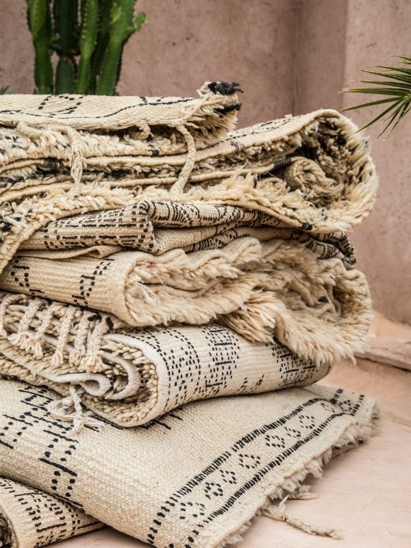 A stack of folded up vintage Beni Ourain rugs - Nouvelle Nomad