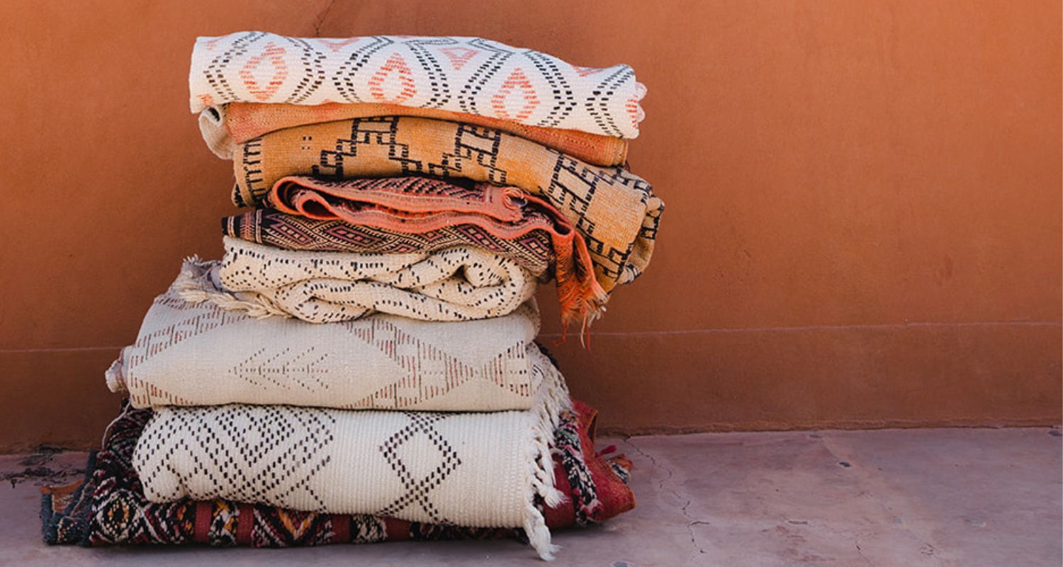 A stack of vintage Moroccan rugs Nouvelle Nomad