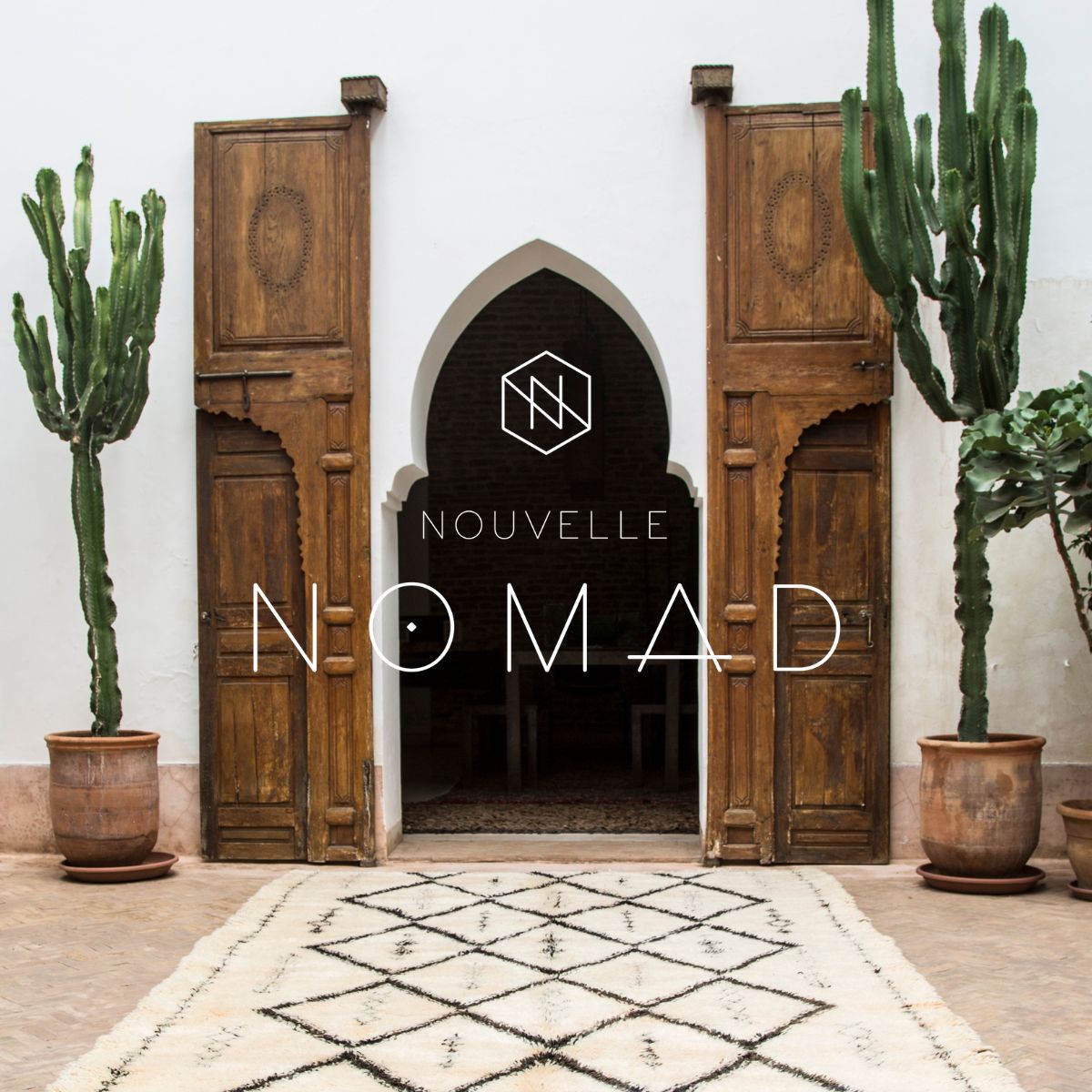 A Nouvelle Nomad Beni Ourain rug in front of Moroccan doors with cactus pots